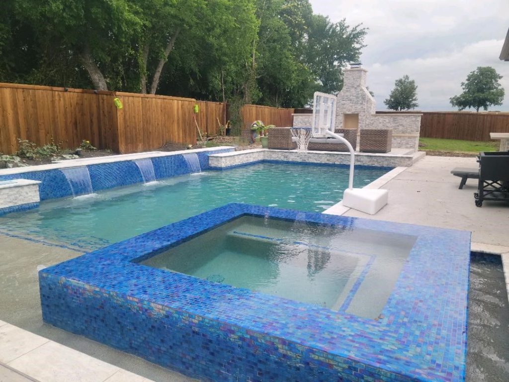 Modern geometric pool with iridescent glass-tile spa and sheer-descent scuppers — Prosper